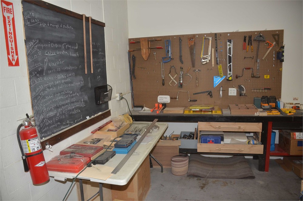 Hand tools on table, bench, and wall